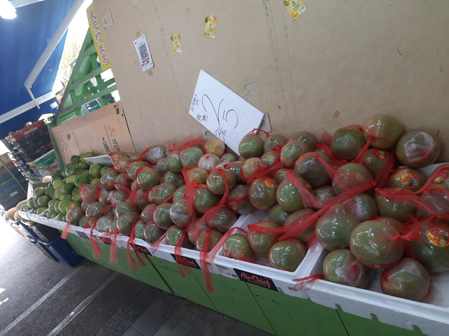 Rows of netted fruit displayed outside Lian Hua Chun Fruit
